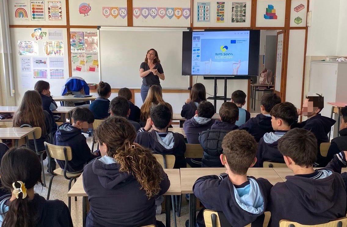 Una ponent en una aula amb alumnes. 