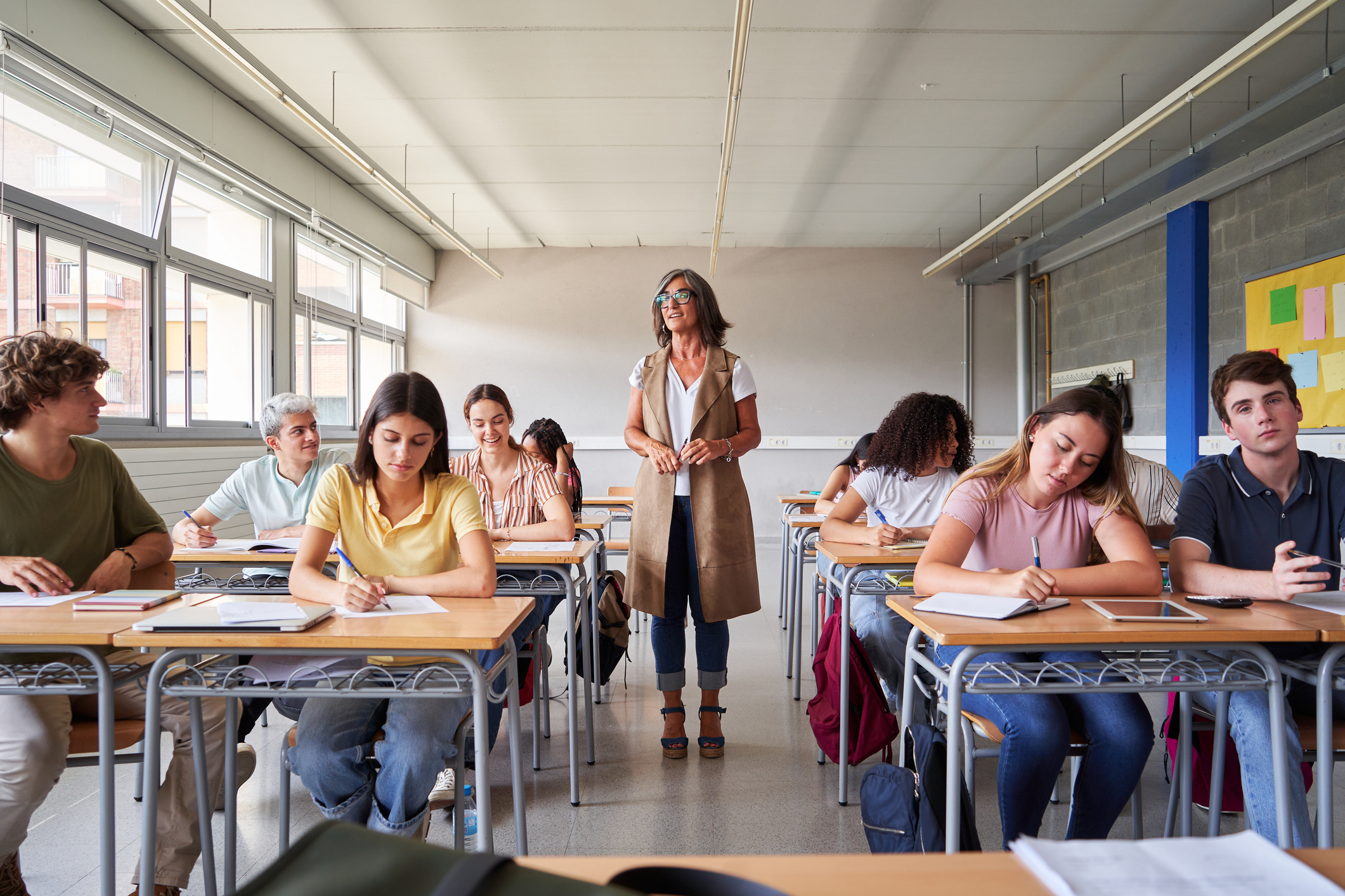 Joves alumnes en una aula escolten una professora.