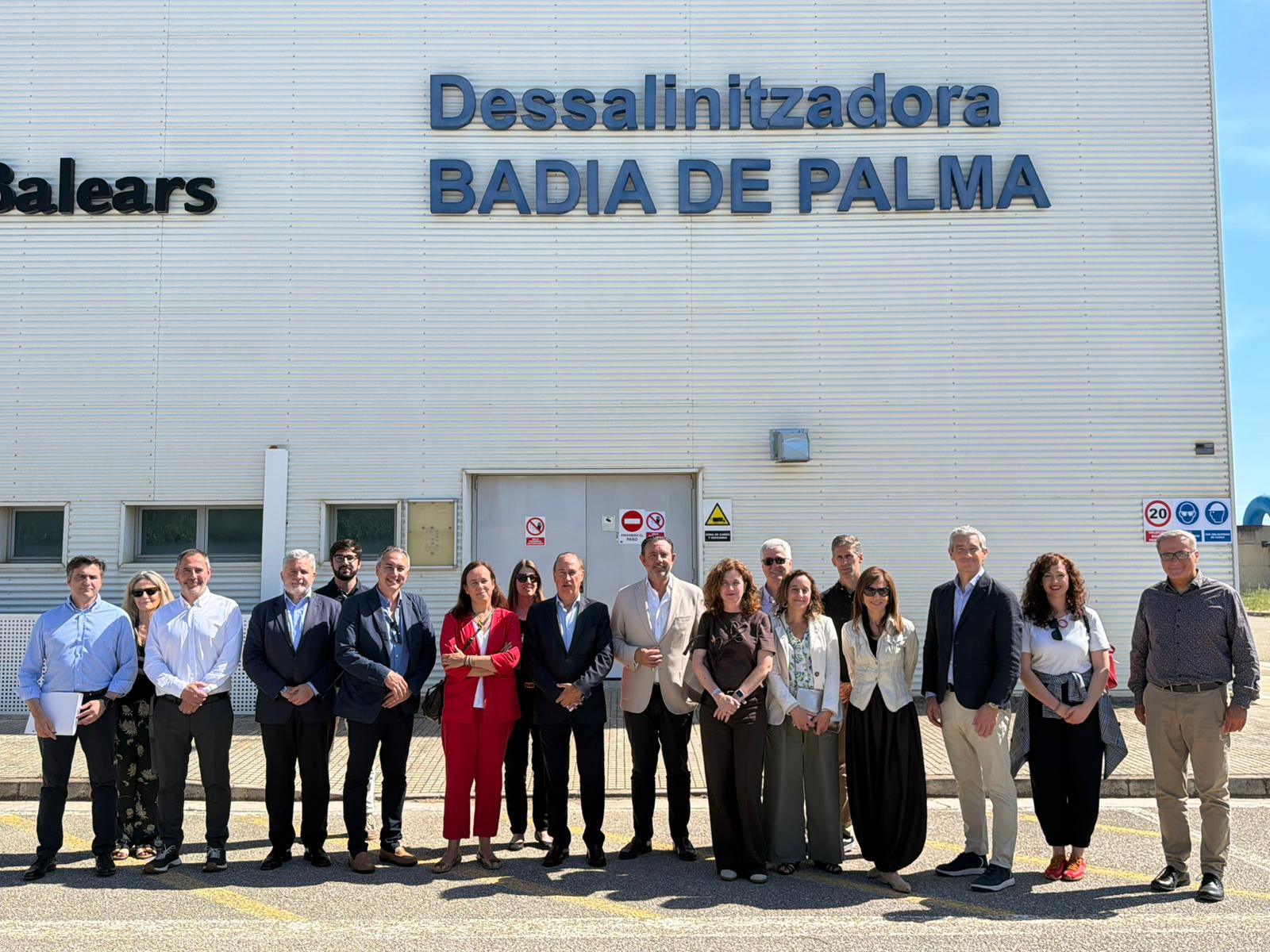 Foto de família de les autoritats participants en la visita, davant la dessaladora