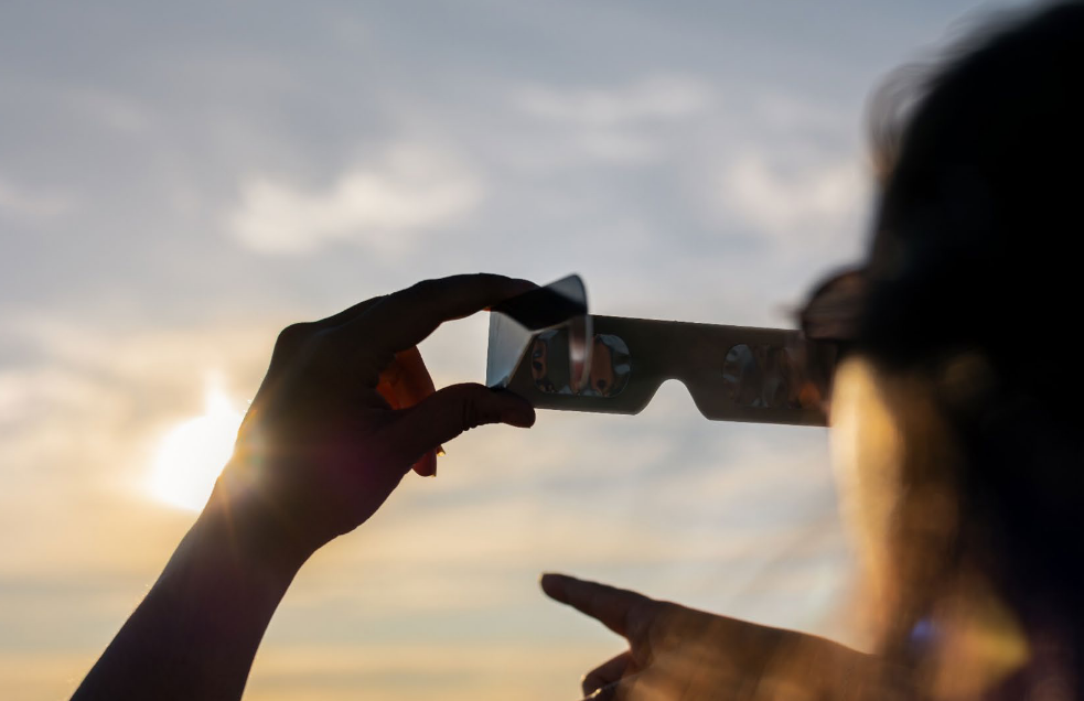 Una dona mira el sol amb unes ulleres de seguretat