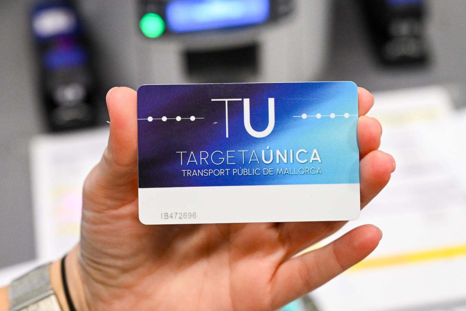 Una mà d'home sosté una Tarjeta Única de transport