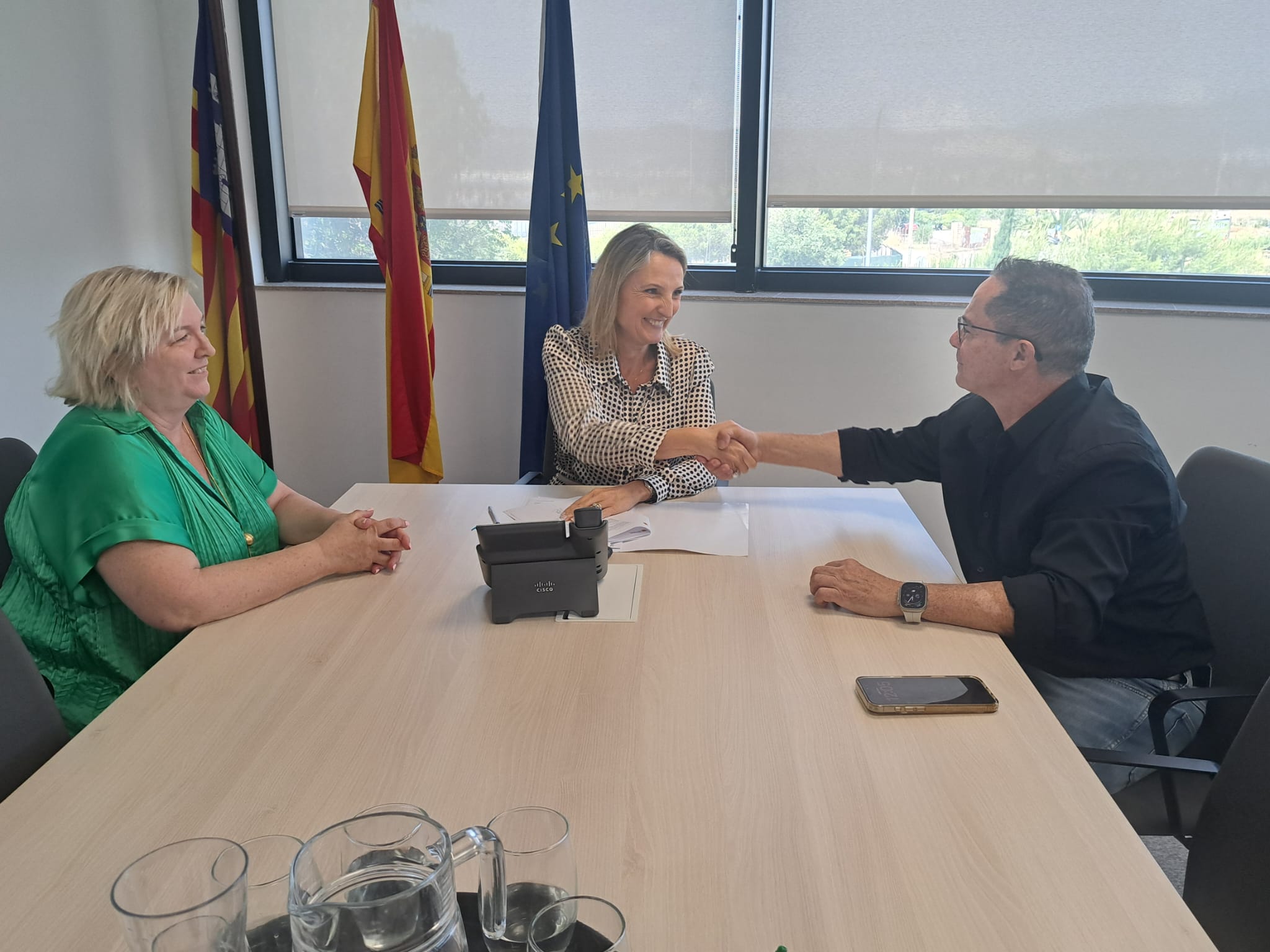 La consellera de Treball, Funció Pública i Diàleg Social, Catalina Cabrer, i el secretari general d’UGT Serveis Públics a les Balears, Miguel Ángel Romero, es donen la mà en presència de la directora general de Funció Pública, Maria Violeta Rodríguez