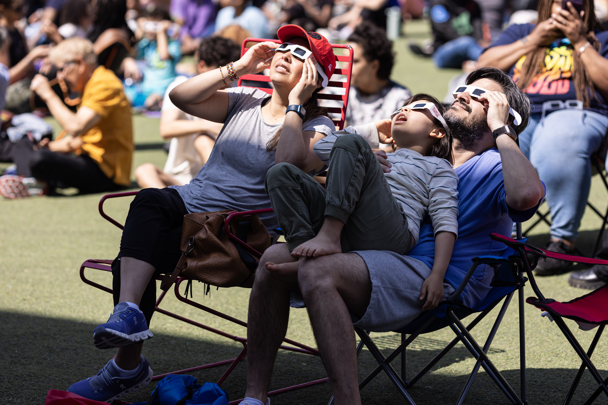 Un grup de persones miren un eclipse de sol amb ulleres homologades
