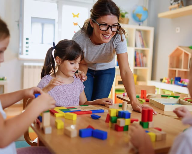 Un grup d'infants i una professora a una escoleta infantil