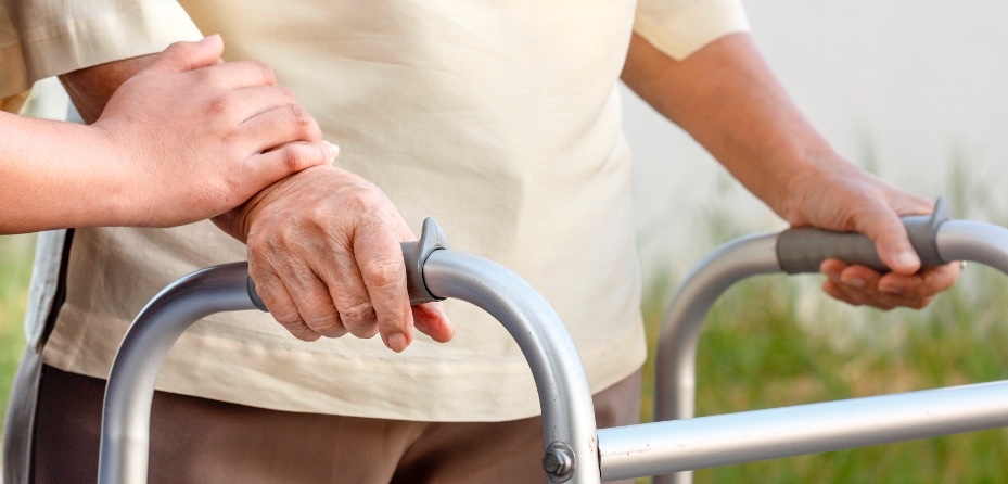 Un home major camina amb ajuda
