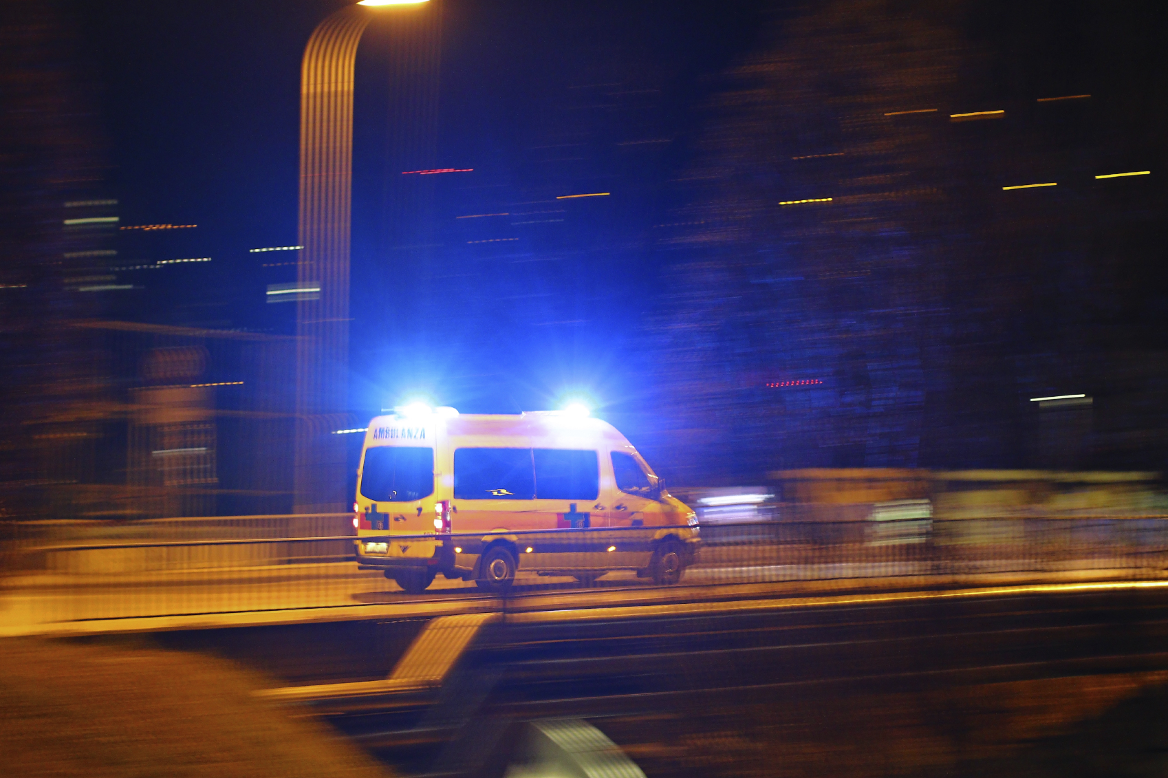Una ambulància amb els llums d'emergència circula per un carrer de nit