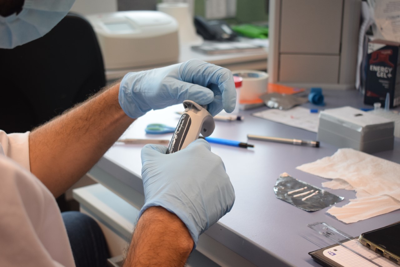 Les mans d'un investigador manipulen un aparell.