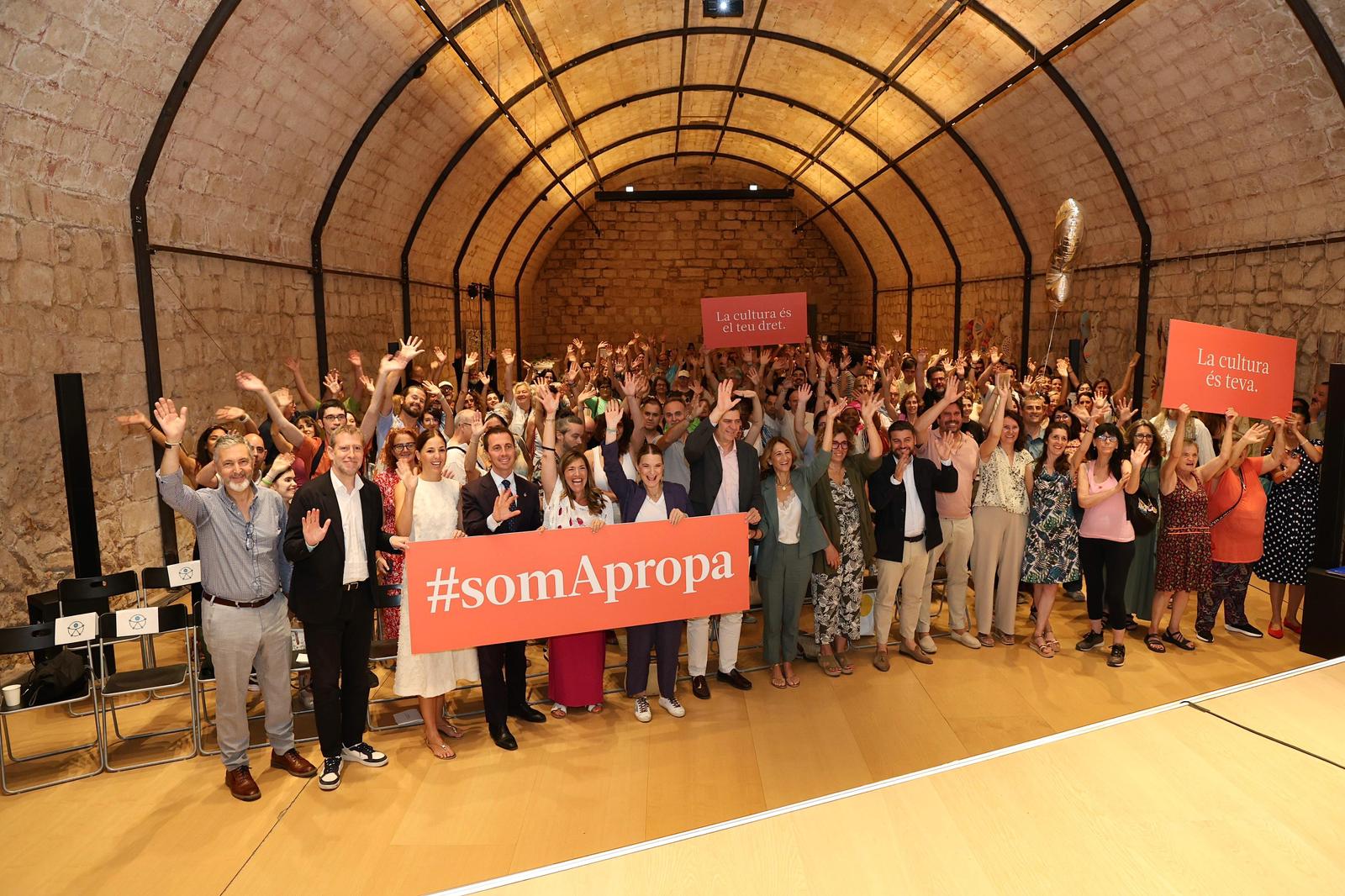  Els participants en el 5è aniversari d’Apropa Cultura saluden a la càmara, juntament amb les autoritats