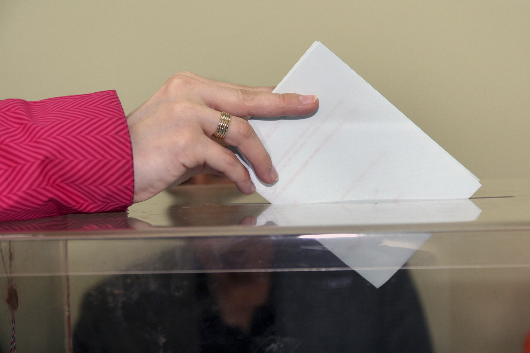 Una mà intodueix un vot en una urna. 