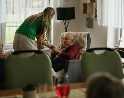 Una dona té cura d'una persona gran a una habitació