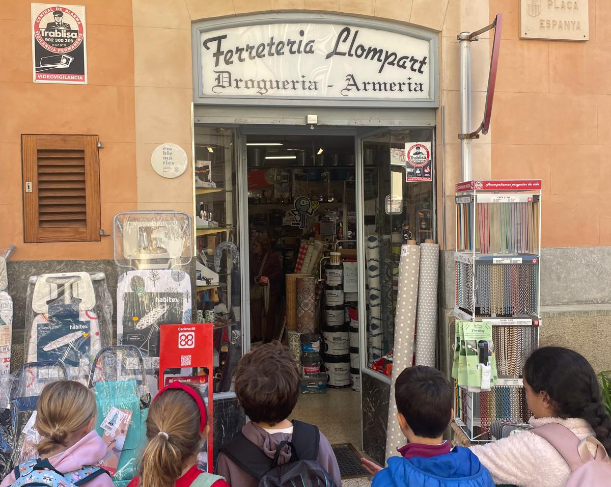Un grup d'escolars davant la porta d'un comerç.