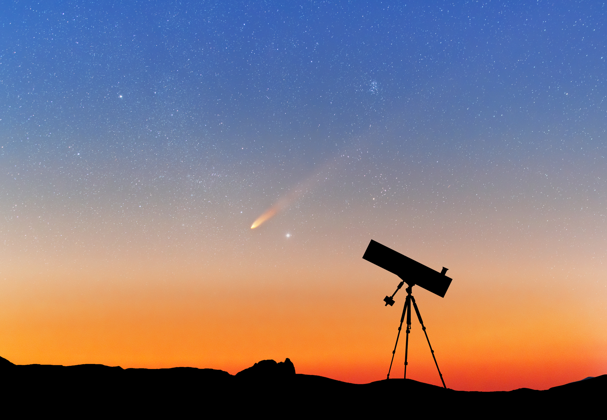 Un telescopi amb una posta de sol al fons