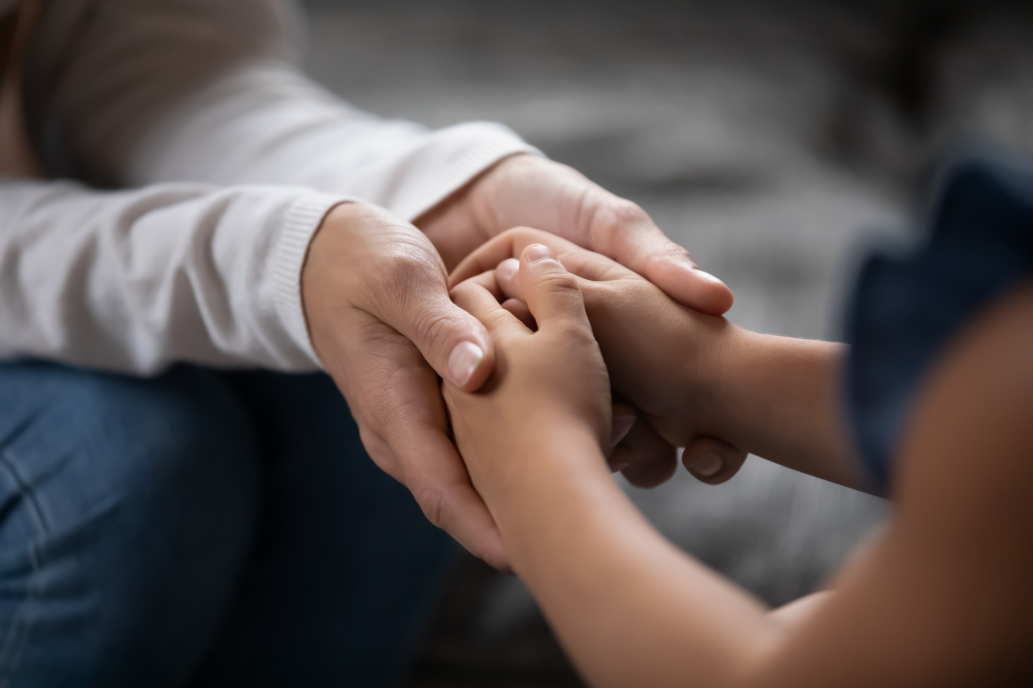 Una persona adulta sosté les mans d'un infant.