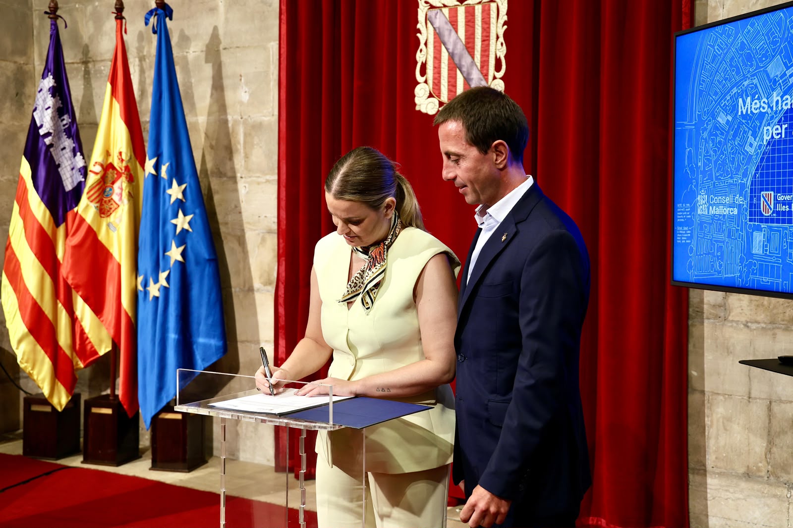 La presidenta Prohens, acompanyada del president del Consell de Mallorca, Llorenç Galmés, signa l'acord.
